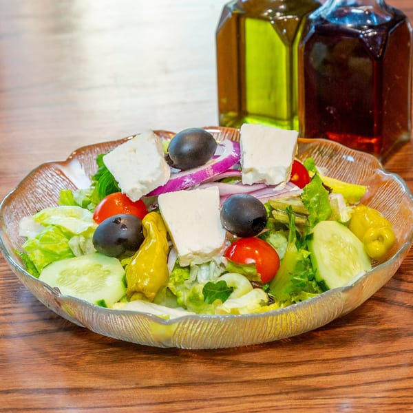 Fresh Persian salad with lettuce, cucumbers, tomatoes, feta, olives, and red onion.